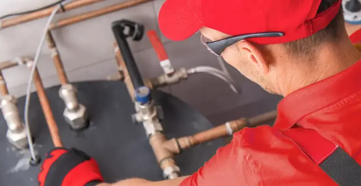Technician inspecting water heater pipes and connections